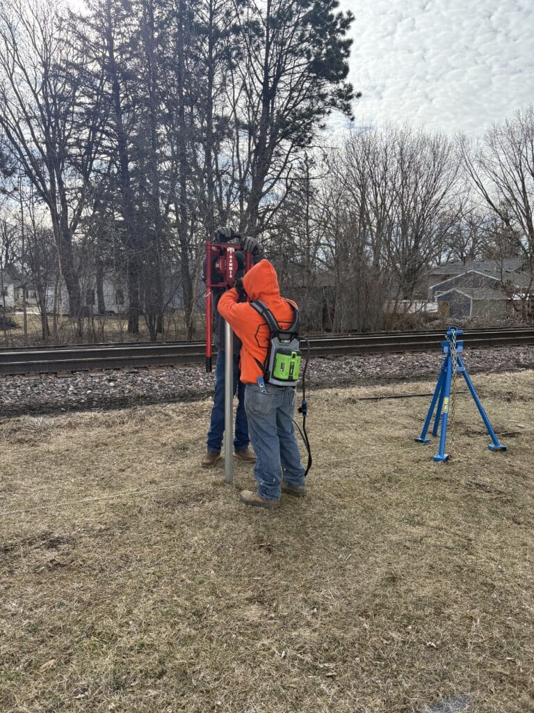 Fence installation training: Pounding a post with new, electric post pounder from US Hammer with the NW Quik Pull off to the side.